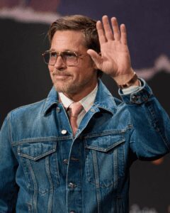 Brad Pitt saluda con chaqueta de mezclilla y gafas