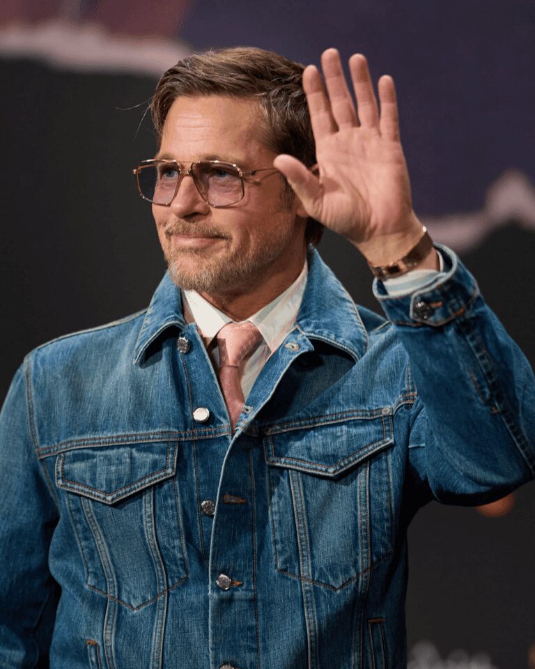 Brad Pitt saluda con chaqueta de mezclilla y gafas